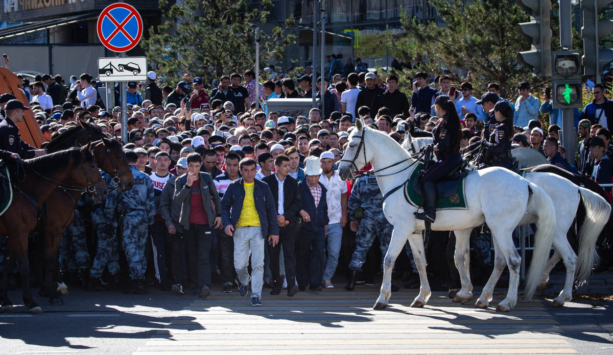 Russian police officers help Muslim believers cross a street following the annual celebration of Eid al-Fitr in Moscow, Russia, Tuesday, June 4, 2019. Eid al-Fitr marks the end of the Muslims'' holy fa