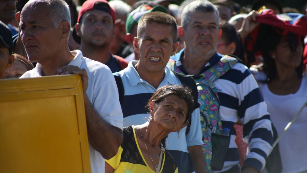People wait to cross the Colombian-Venezuelan border over the partially opened Simon Bolivar international bridge in San Antonio del Tachira