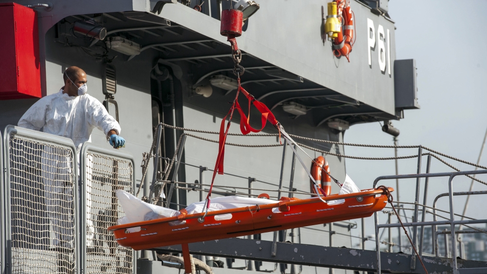 A body is being lowered from a Maltese Navy ship at the Valletta harbor, Malta, Saturday, Oct. 12, 2013. A Maltese ship has brought 143 survivors from a capsized smugglers' boat to Malta while a sear