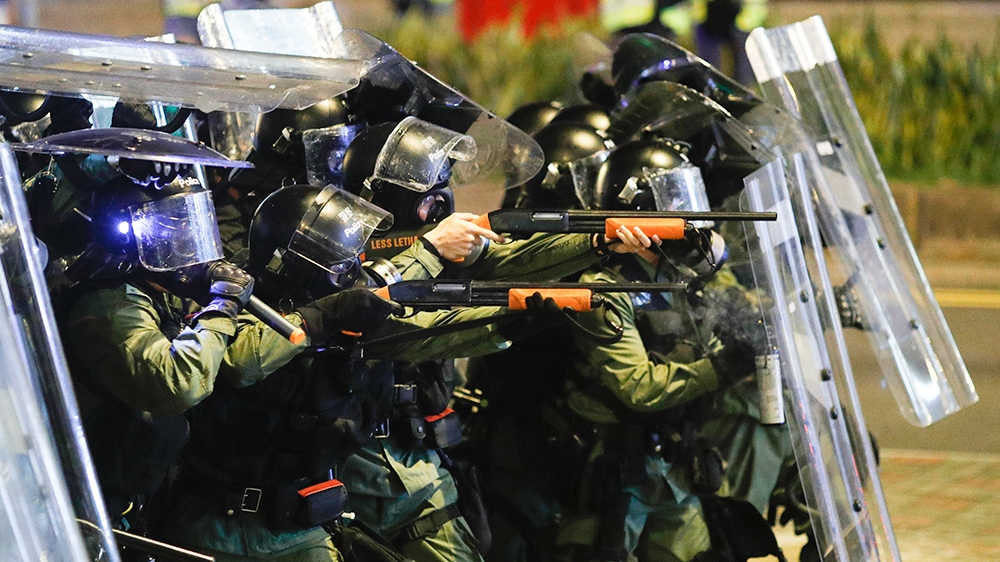 Riot police officer point weapons during confrontation with protesters in Hong Kong on Sunday, July 21, 2019. Protesters in Hong Kong pressed on Sunday past the designated end point for a march in whi