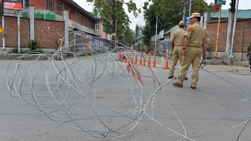 Policemen stand guard on a street during curfew in Srinagar on August 7, 2019. - A protester died after being chased by police during a curfew in Kashmir's main city, left in turmoil by an Indian gove