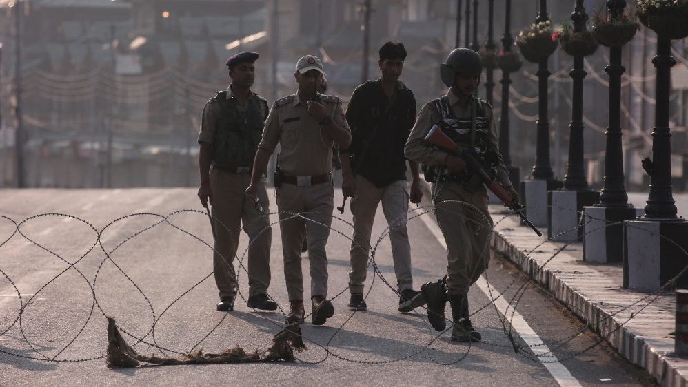 Indian security personnel patrol on deserted road during restrictions in Srinagar