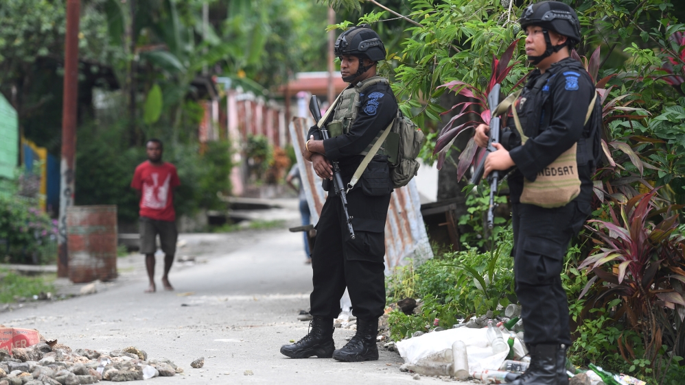 Police Mobile Brigade (Brimob) officers stand guard near Nayak Abepura student dormitory in Jayapura