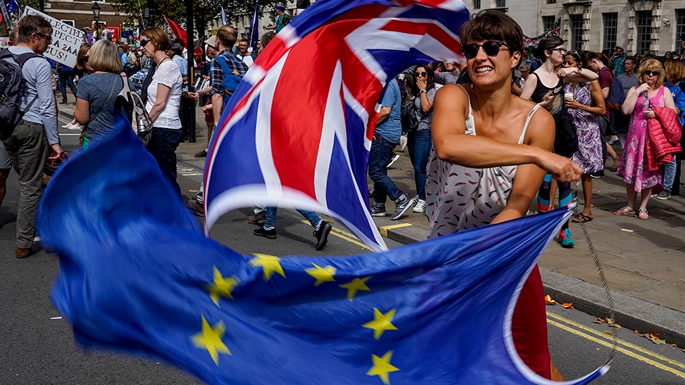 An anti-Brexit demonstrator whirls an EU and Union Flag during a demonstration against the British government''s move to suspend parliament in the final weeks before Brexit outside Downing Street in Lo