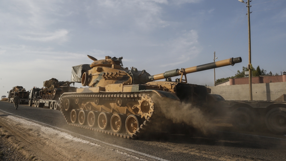 A Turkish forces tank is driven to its new position after was transported by trucks, on a road towards the border with Syria in Sanliurfa province, Turkey, on Monday, Oct. 14, 2019
