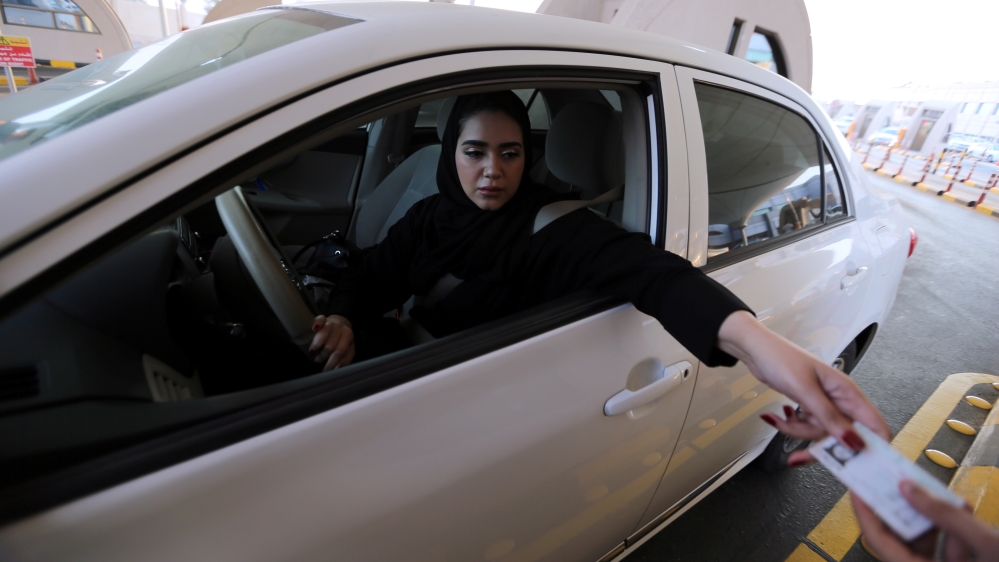 Saudi woman shows her national ID card at the Bahrain immigration checkpoint, as she drives to Bahrain on the King Fahd Causeway