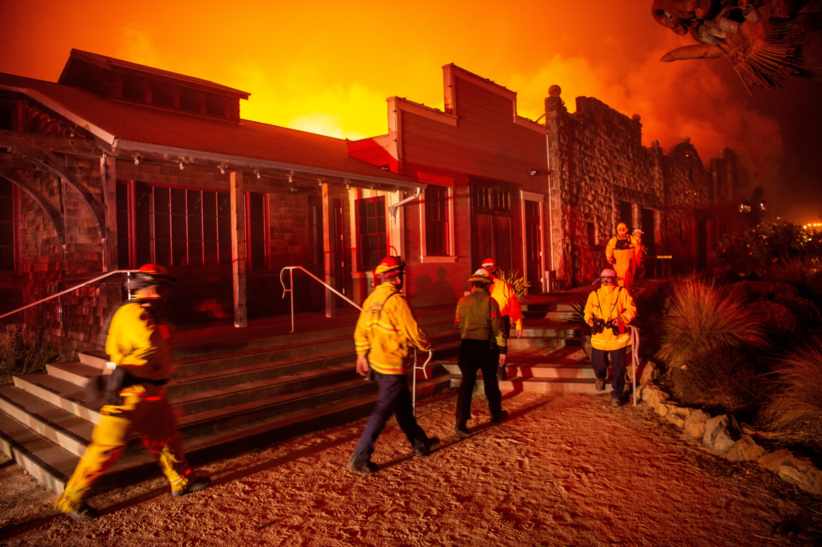 Firefighters survey the Soda Rock Winery as it burns during the Kincade fire as flames race through Healdsburg, California on October 27, 2019. - Powerful winds were fanning wildfires in northern Cali