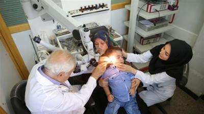 Two-year-old Emad's doctor Mr. Khorasandy checks his ear i