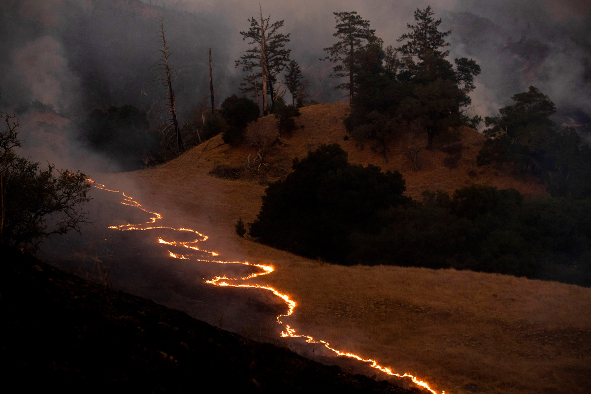 A line of fire snakes along a hillside as firefighters light backfires to slow the spread of the Kincade Fire in unincorporated Sonoma County, Calif., near Geyservillle, on Saturday, Oct. 26, 2019. Th