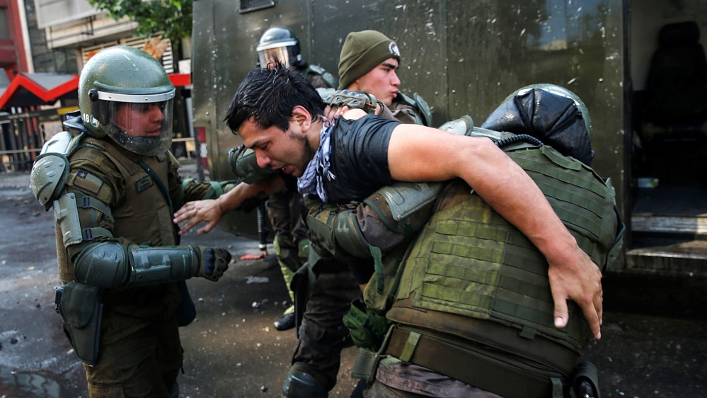 Police officers detain a demonstrator during a protest against Chile's state economic model in Santiago October 20, 2019. REUTERS/Edgard Garrido