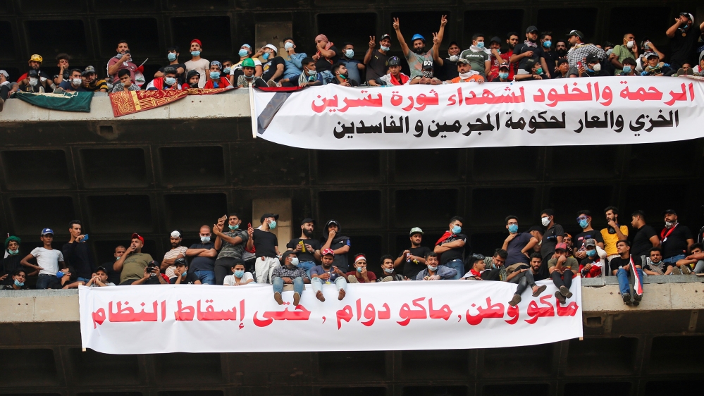 Demonstrators display a banner that reads 
