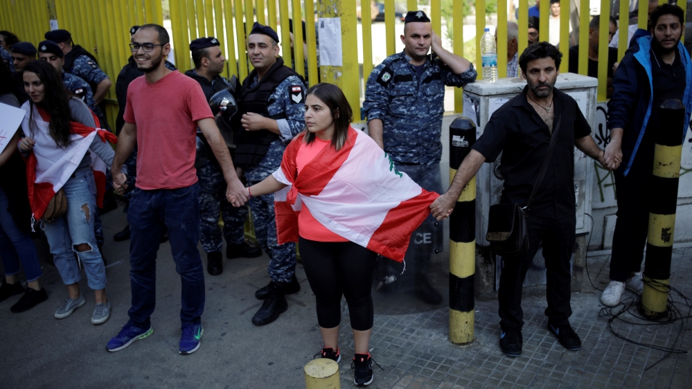 Demonstrators stand blocking access to the state owned electricity company during ongoing anti-government protests in Beirut