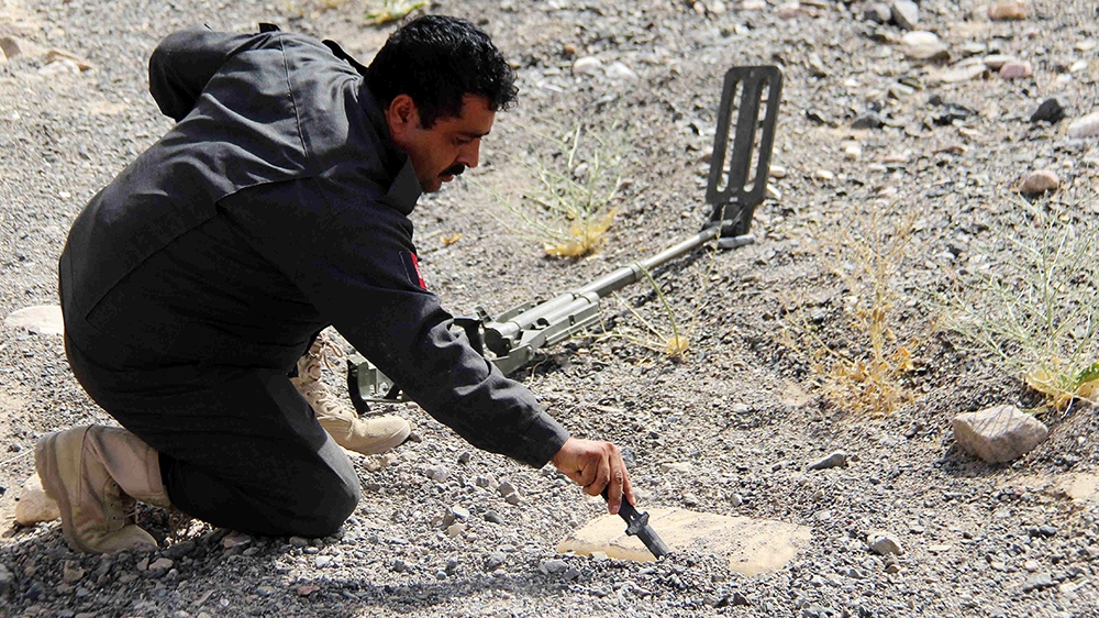 Sirajuddin Afghanmal, an Afghan police official, detects and removes land mines planted by suspected militants in Maiwand district of Kandahar, Afghanistan