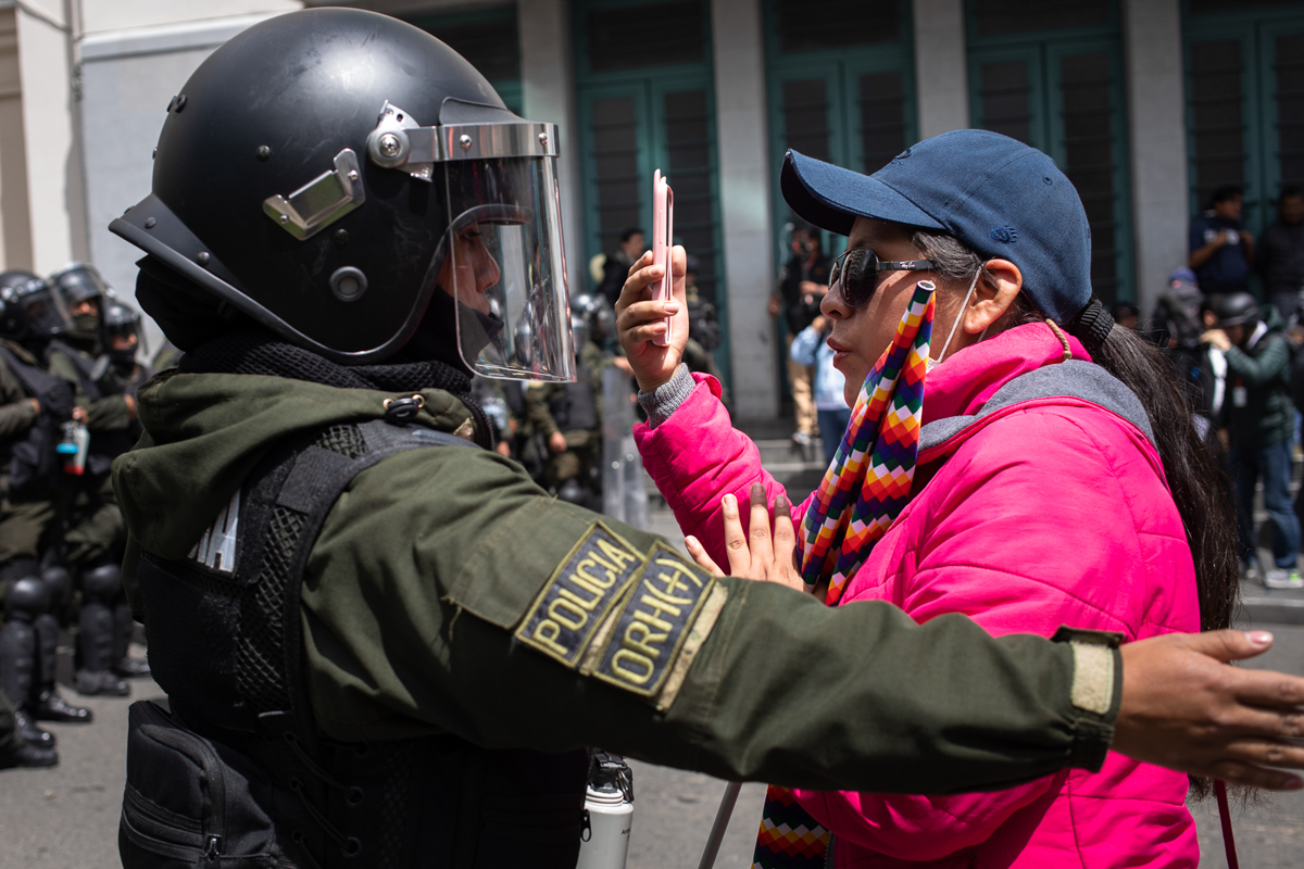 A police woman asks a protestor to step backwards from a barricade during demonstrations in support of the ousted president Evo Morales La Paz, Bolivia. Nov. 15, 2019 © Erika Pin~eros