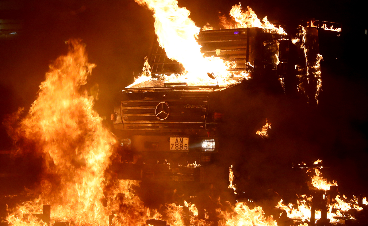 A police vehicle catches fire after being hit with molotov cocktails, as anti-government protesters clash with police, outside Hong Kong Polytechnic University (PolyU) in Hong Kong, China, November 17