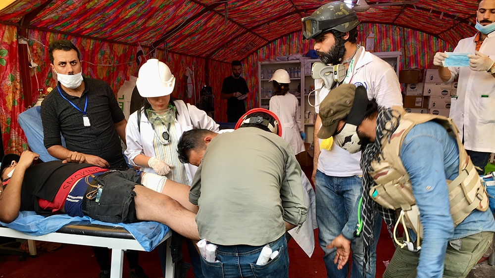  Volunteer medics treat a protester wound following clashes with security forces [Sofia Barbarani/Al Jazeera]