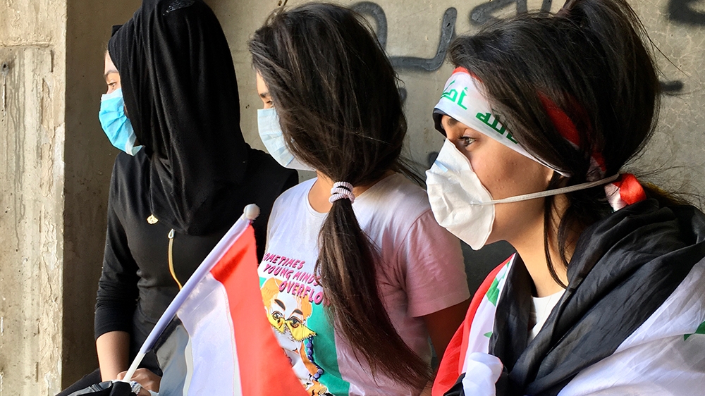 three young women look out into Tahrir square [Sofia Barbarani/Al Jazeera]