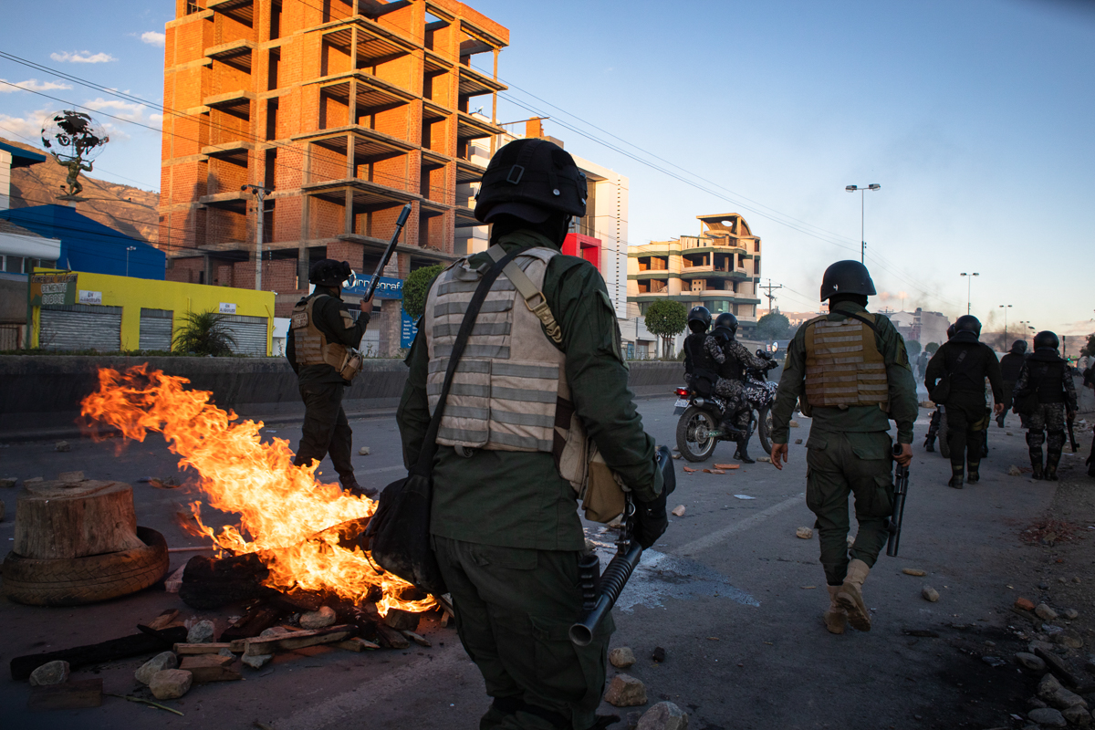 Loaded with teargas, antiriot police move towards demonstrators after violence erupted during a demonstration by supporters of Evo Morales. Over 3,000 protesters demanded access to Cochabamaba where t