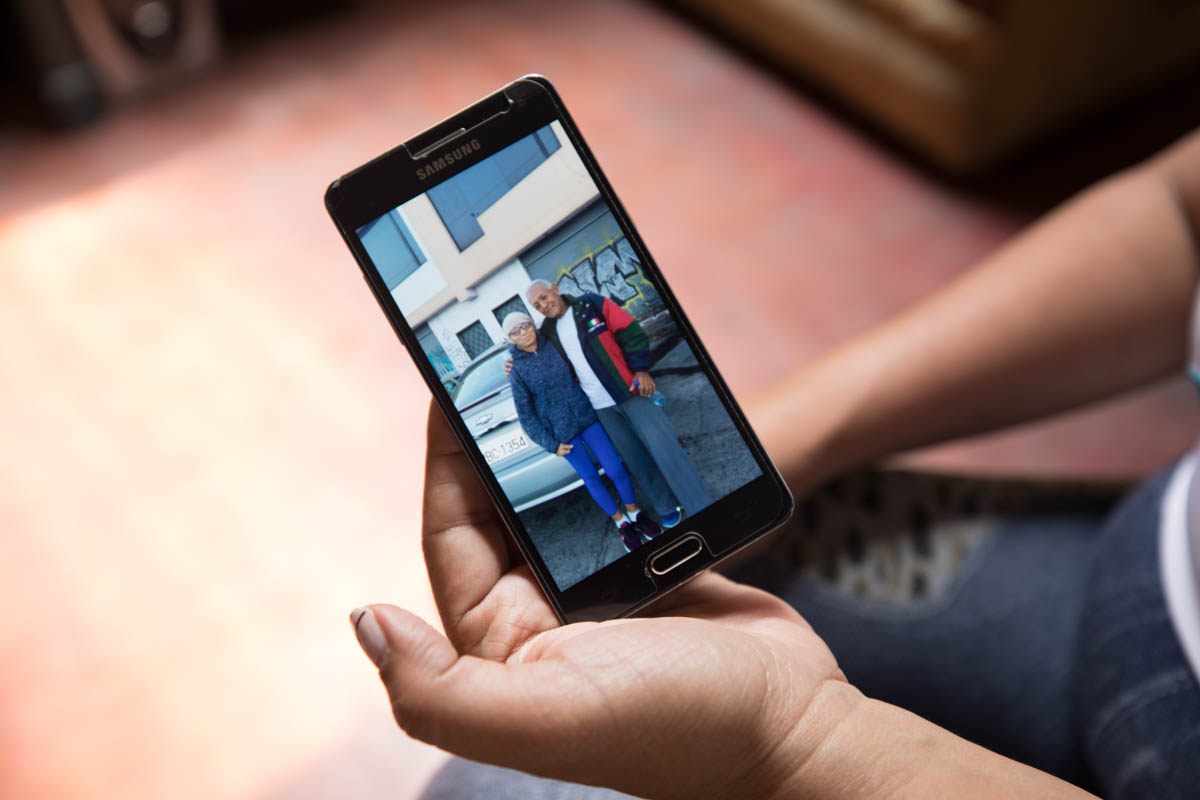 Ana, a lawyer, shows a photo of her father on her phone. When she first came to Ecuador, she could not bring her father along. Ana would send her what little money she could save to help pay for his m