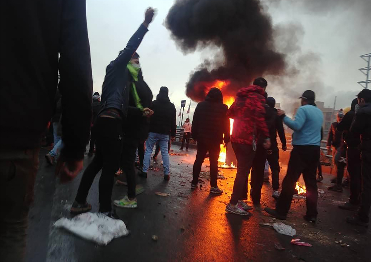 Iranian protesters gather around a fire during a demonstration against an increase in gasoline prices in the capital Tehran, on November 16, 2019. - One person was killed and others injured in protest