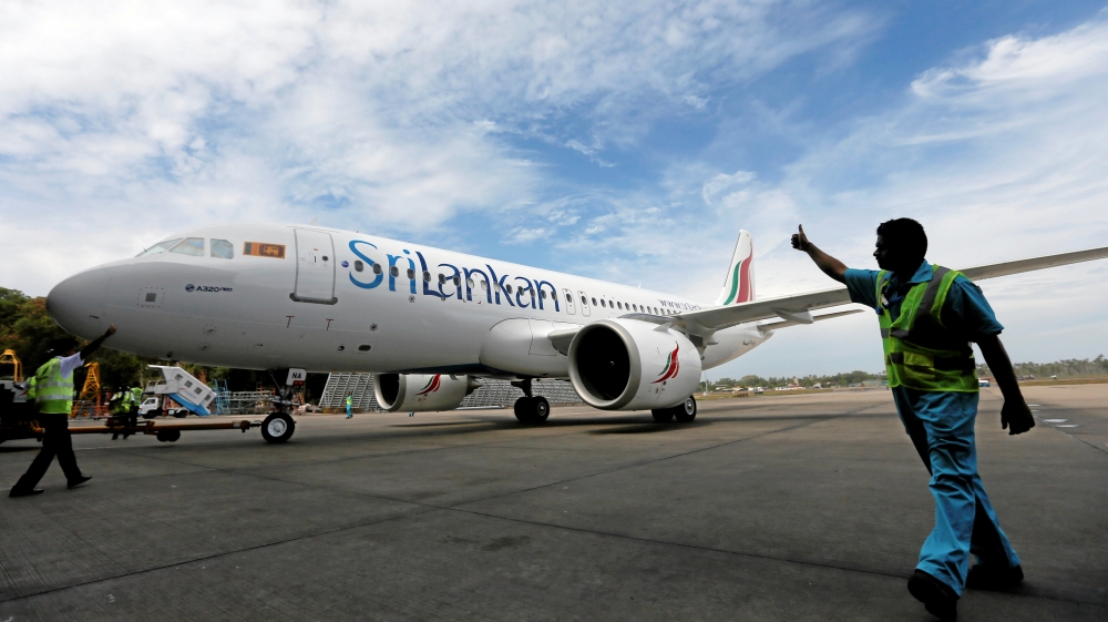 A flight deck director signals to a newly ordered Sri Lankan Airlines A320neo plane at Bandaranaike International Airport in Katunayake
