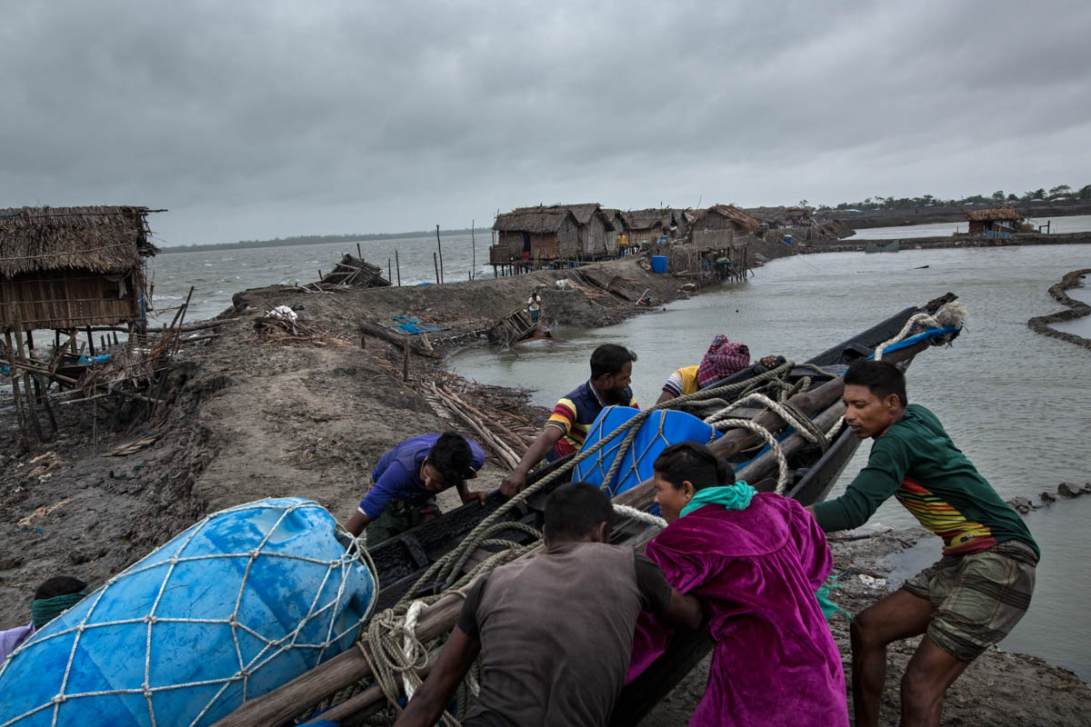 Coastal people trying to escape their boat during cyclone near Sundarban area in Bangladesh. These people''s only earning source is fishing in the river and near the sea.