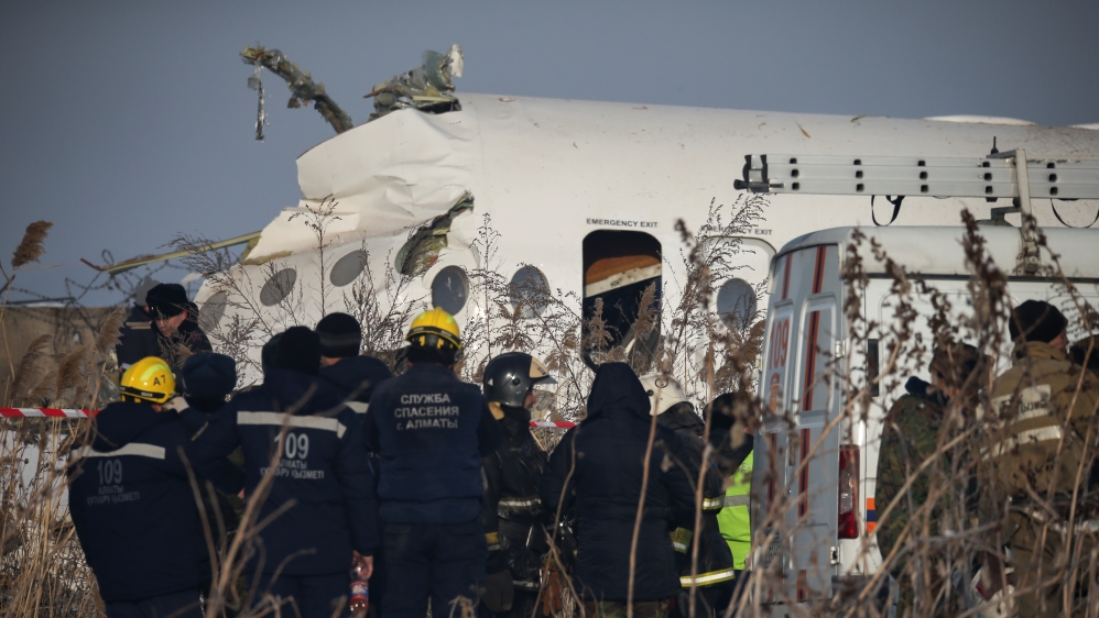 Emergency and security personnel are seen at the site of a plane crash near Almaty