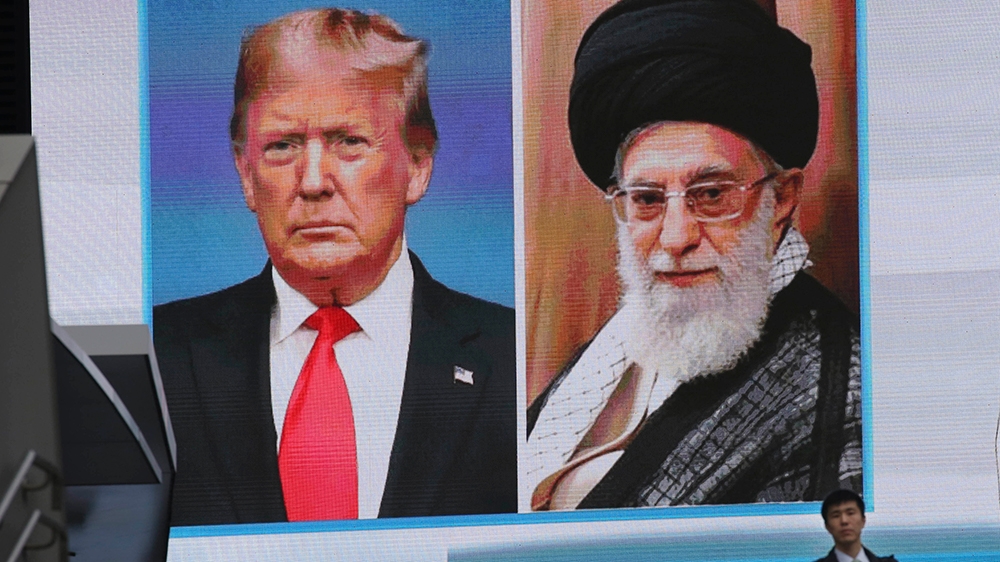 A man walks by a huge screen showing U.S. President Donald Trump, left, and Iranian Supreme Leader Ayatollah Ali Khamenei in Tokyo, Wednesday, Jan. 8, 2020. (AP Photo/Koji Sasahara)