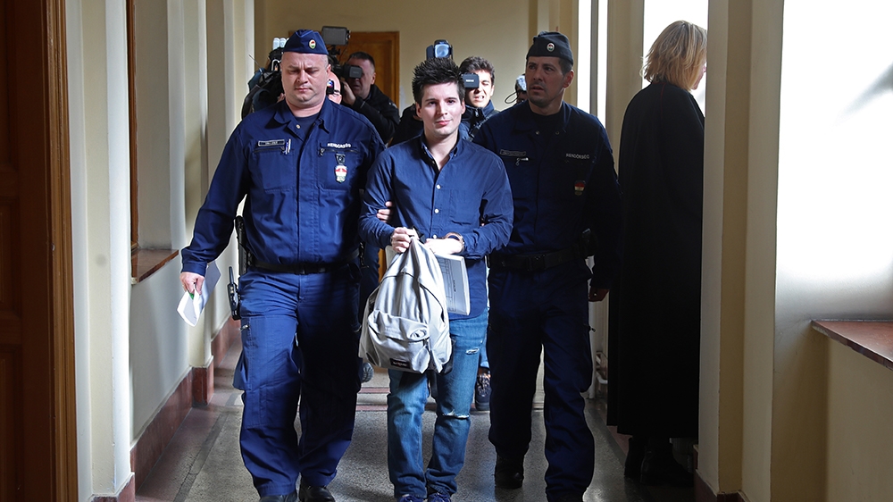 (FILES) In this file photo taken on March 5, 2019 Football Leaks whistleblower Rui Pinto (C) is escorted by judicial officers as he arrives at the Metropolitan Court in Budapest, Hungary, for his tria