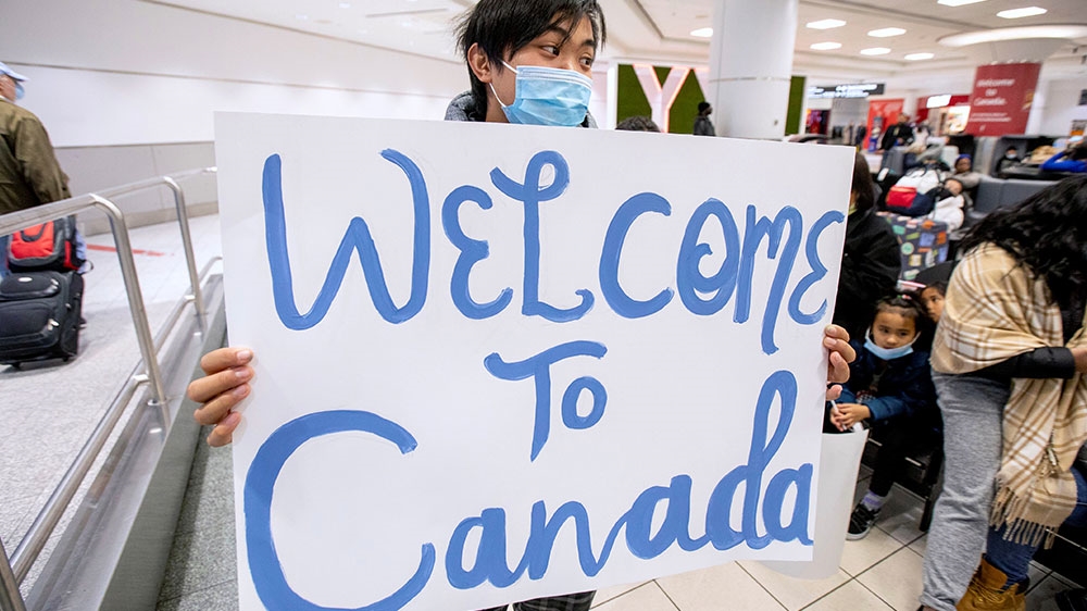 A man waits for a family friend while wearing a mask at Pearson airport arrivals, shortly after Toronto Public Health received notification of Canada”s first confirmed case of coronavirus, in Toronto, Ontario