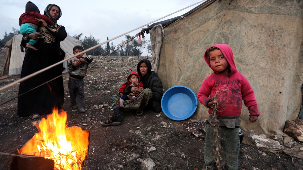 Displaced Syrian women and children, who fled from southern Idlib, gather around a fire in Afrin, Syria February 6, 2020. Picture taken February 6, 2020. REUTERS/Khalil Ashawi TPX IMAGES OF THE DAY