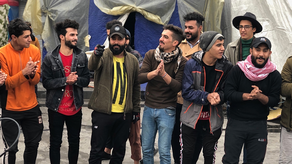 A group of Iraqi university students sing popular chants against the government