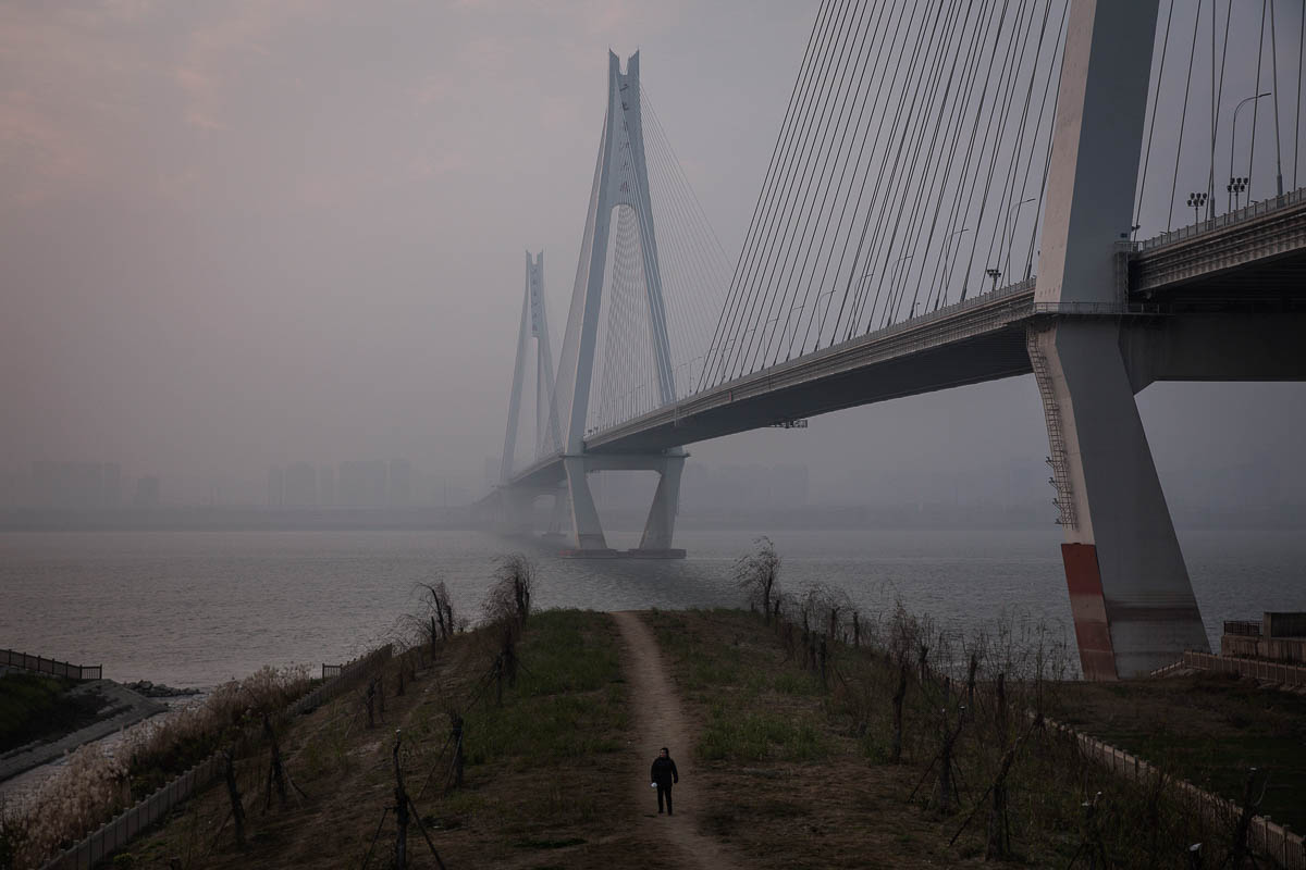 WUHAN, CHINA - FEBRUARY 05: A man walking along the Yangtze River on February 5, 2020 in Wuhan, Hubei province, China. Flights, trains and public transport including buses, subway and ferry services h