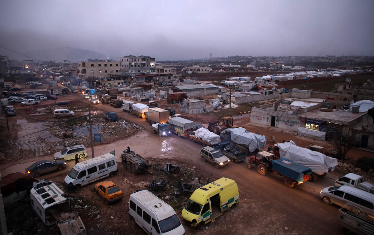A large convoy of displaced Syrians who fled pro-regime attacks on rebel-held areas of the Idlib province, drive through the town of Dana, east of the Turkish-Syrian border toward safer parts of the s