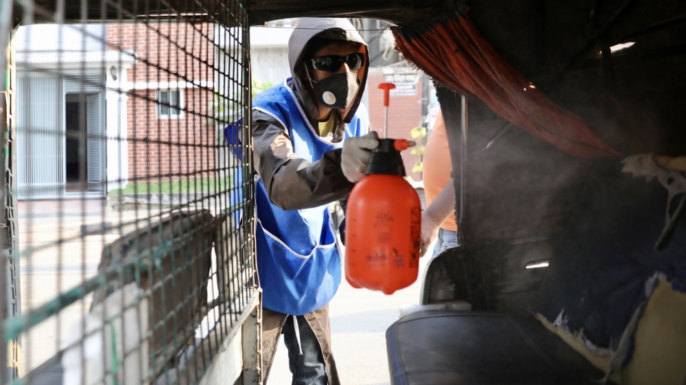 A volunteer sprays disinfectant inside an auto-rickshaw amid concerns about the spread of coronavirus disease (COVID-19) in Dhaka