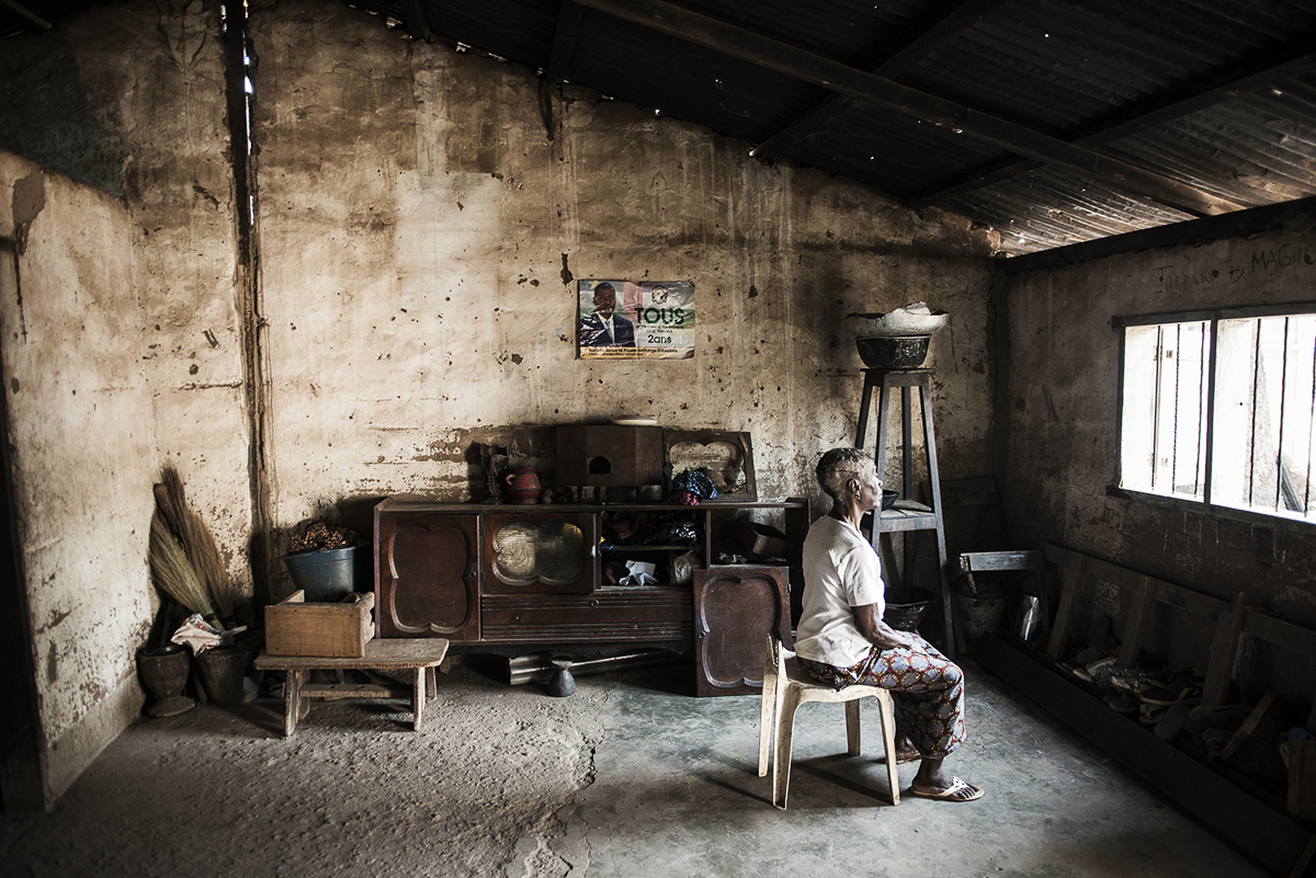 Hélène Ndenjia, charged with witchcraft, looks through the window of her house in Bangui. Hélène was accused of sorcery by her own nephew: the son of her sister believes that Hélène is the cause of hi