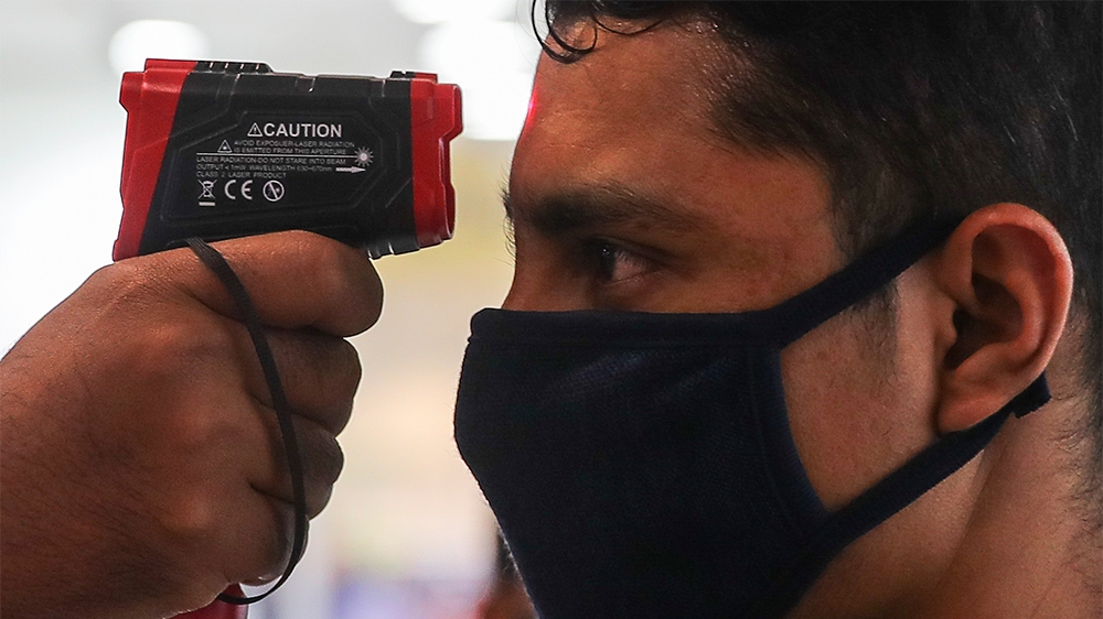 epaselect epa08302952 Security officers check the tempature of visitors inside a closed shopping mall during the first day of a movement control order issued by the Malaysia government, Malaysia, 18 M