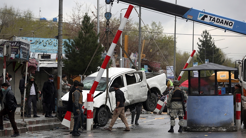 A damaged vehicle is removed from the site of a bomb explosion in Kabul, Afghanistan, Monday, March 30, 2020. At lest four people were wounded when a sticky bomb attached to vehicle detonated, said ac