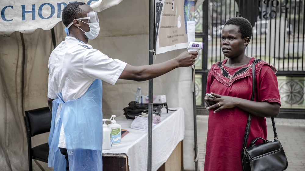 Health personnel measure the temperature of a visitor at the entrance of the Coptic Hospital in Nairobi, Kenya on March 18, 2020. The Government of Kenya confirmed new positive cases of COVID-19 coron