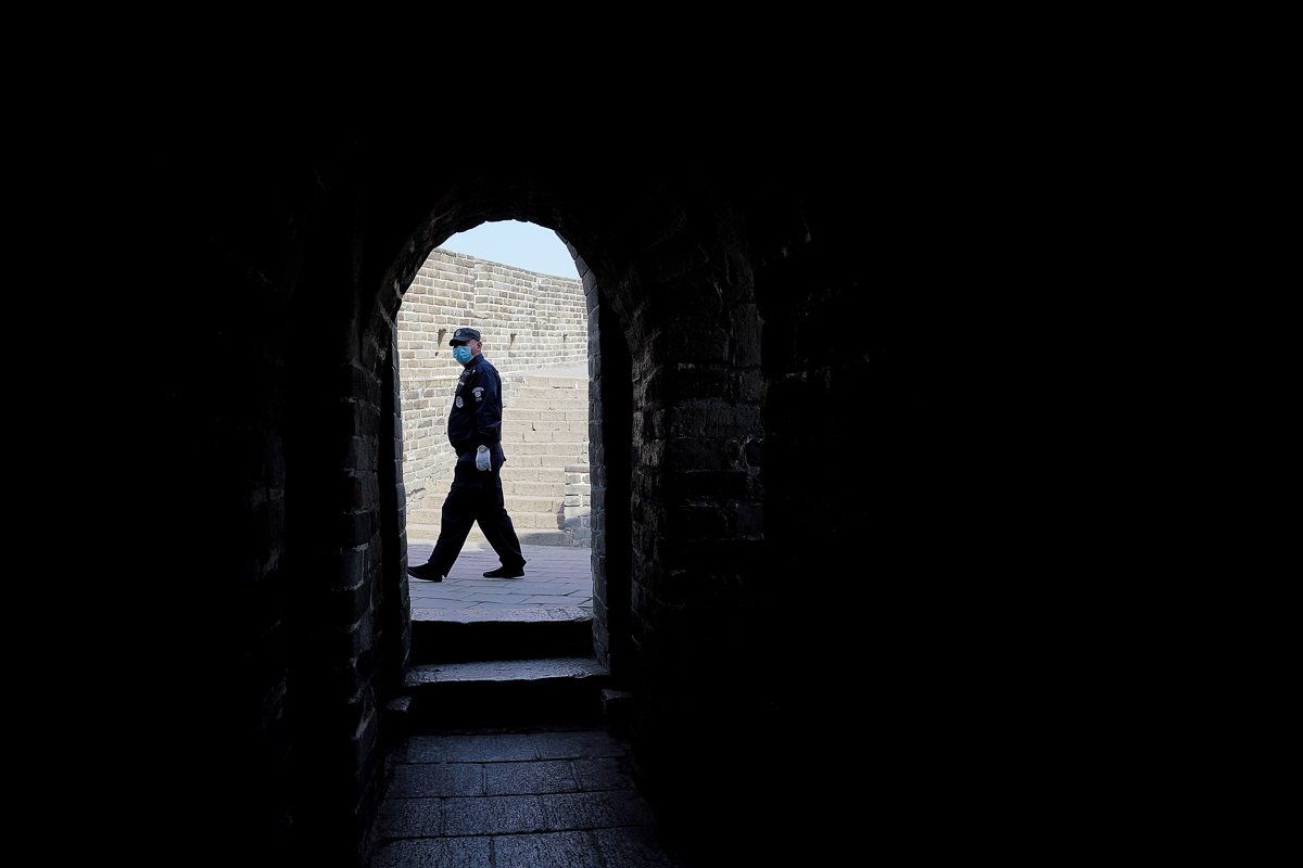 BEIJING, CHINA - MARCH 24: A security guard wears a protective mask at the almost empty Badaling Great Wall on March 24, 2020 in Beijing, China. Affected by the new coronavirus covid-19, the Badaling