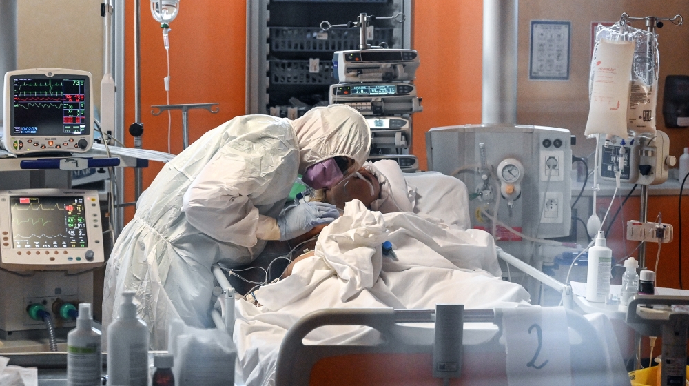 A medical worker in protective gear tends to a patient on March 24, 2020 at the new COVID 3 level intensive care unit for coronavirus COVID-19 cases at the Casal Palocco hospital near Rome, during the