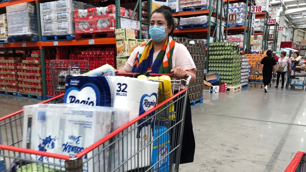 A woman wears a protective mask as she waits to pay at a supermarket during an outbreak of the coronavirus (COVID-19), in Mexico City
