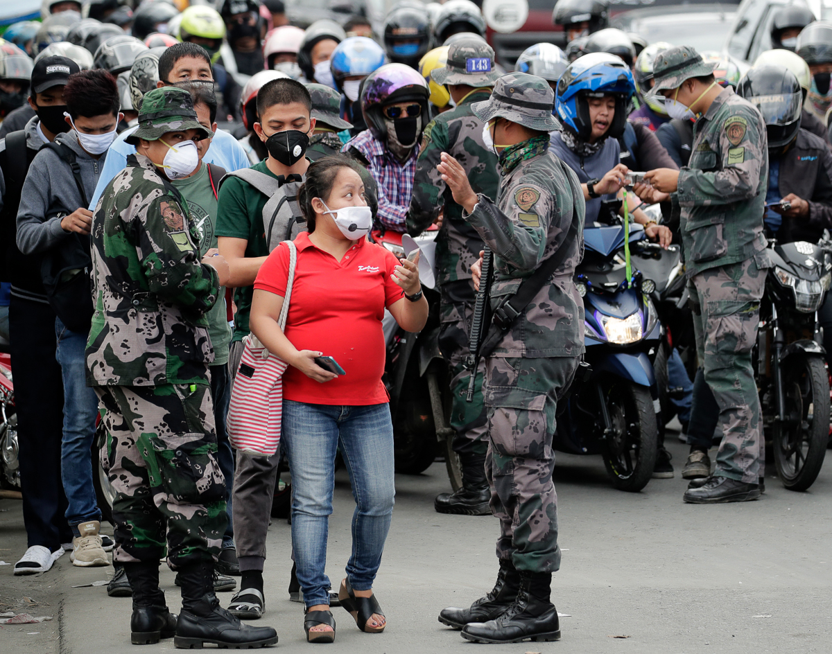 epa08299631 Police officers check documents of people attempting to cross a checkpoint on the border of the City of San Pedro and the City of Muntinlupa in Metro Manila, Philippines, 17 March 2020. Pr