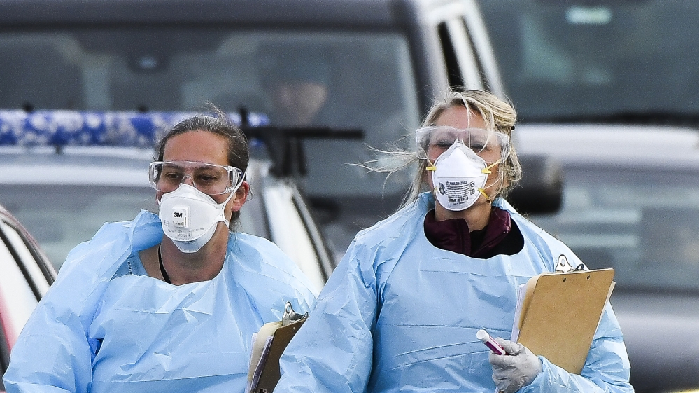  Healthcare workers from the Colorado Department of Public Health and Environment check in with people waiting to be tested for COVID-19 at the state's first drive-up testing center on March 12, 2020 