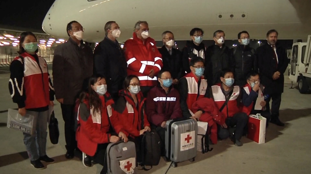 A Chinese team of experts pose for a photograph with head of the Italian Red Cross Francesco Rocca after arriving at Rome?s Fiumicino airport on a chartered plane with a consignment of medical supplie