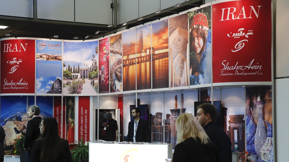 Visitors browse the exhibition stand of Iran at the International Tourism