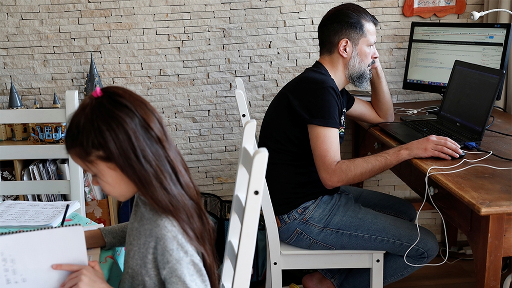Csaba Posta, IT specialist working from home, studies with his daughter Vilma during the spread of coronavirus disease (COVID-19) in Budapest, Hungary March 19, 2020. REUTERS/Bernadett Szabo