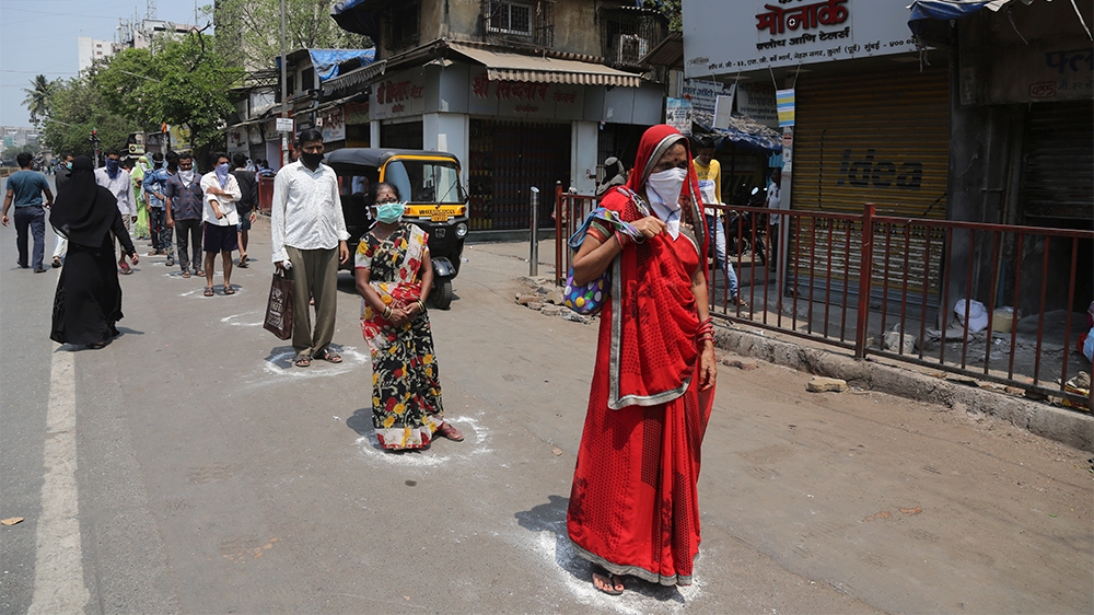 Indians stand in marked positions to buy essential commodities from a grocery store in Mumbai, India, Wednesday, March 25, 2020.The world''s largest democracy went under the world''s biggest lockdown We