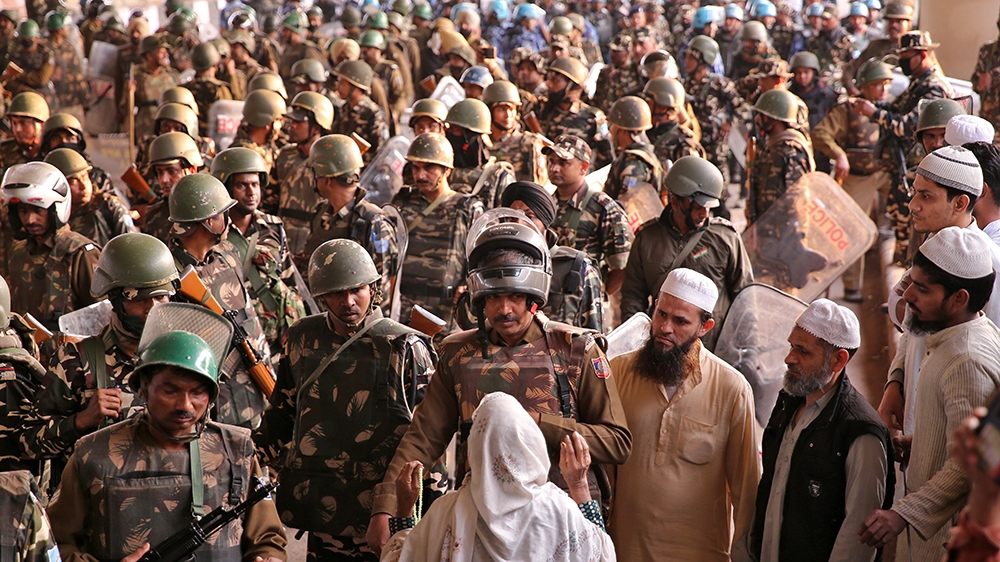 A woman speaks with a police officer during a sit-in protest in a riot affected area after clashes erupted between people demonstrating for and against a new citizenship law in New Delhi, India, Febru