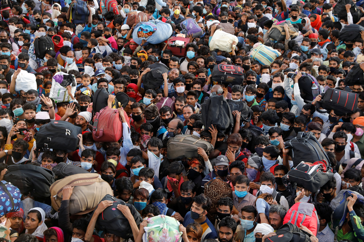Migrant workers crowd up outside a bus station as they wait to board buses to return to their villages during a 21-day nationwide lockdown to limit the spreading of coronavirus disease (COVID-19), in
